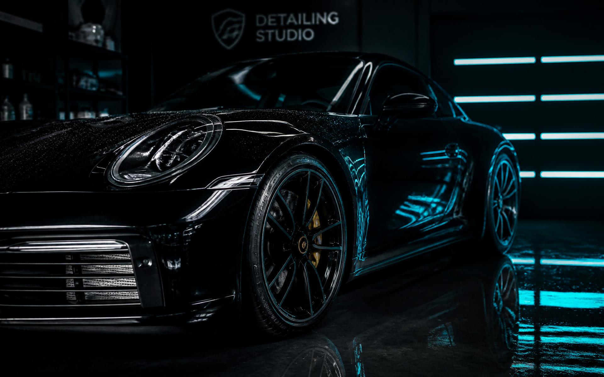 Kiiltävä musta auto detailing-studiossa